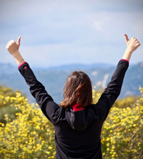 Frau reckt beide Daumen in die Höhe